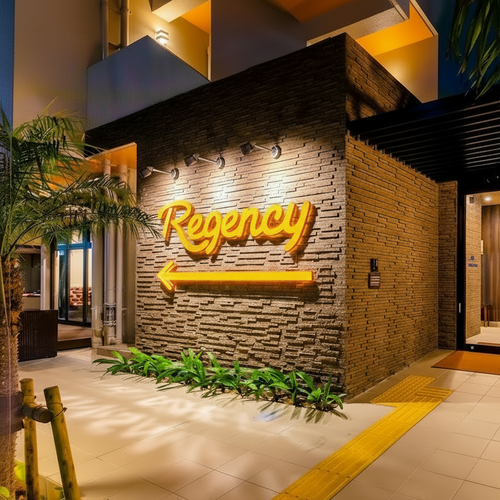 hotel entrance with illuminated sign and outdoor area.